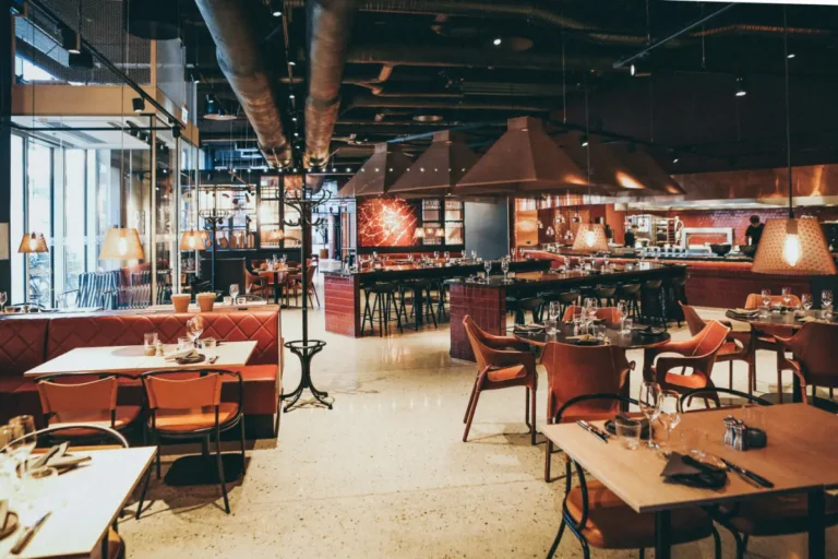 Interior of a modern, fancy restaurant with booths and leather chairs
