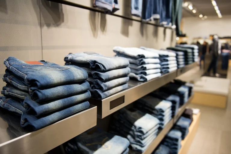 A clothing store with shelves of neatly folded denim jeans in various washes