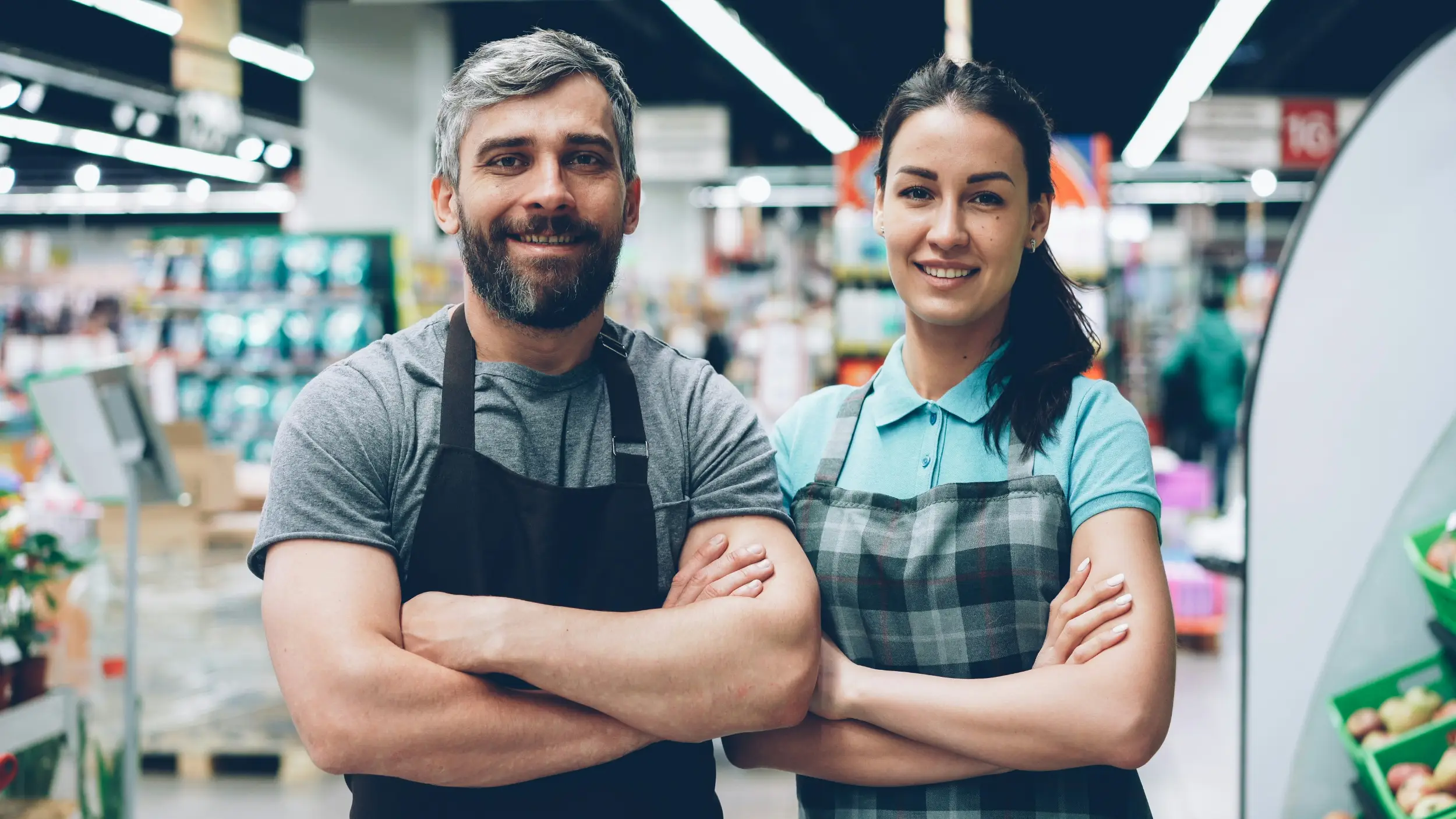 A man and woman, both traveling merchandisers, working in a grocery store